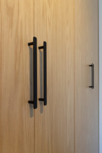 Schrankfront in Eiche mit schwarzen Griffen